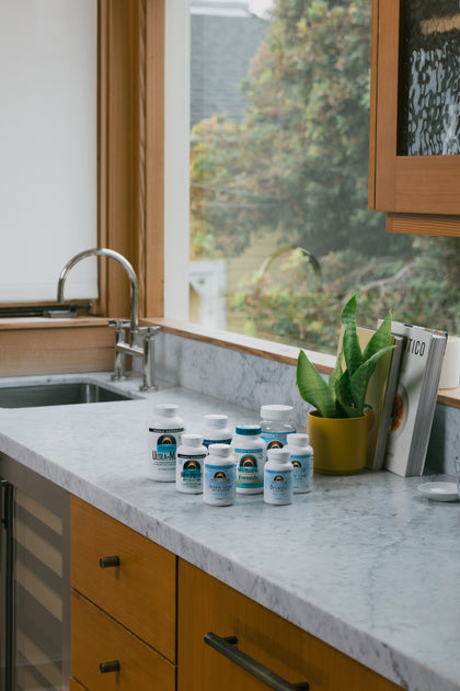 Supplement bottles on a kitchen counter with a window view