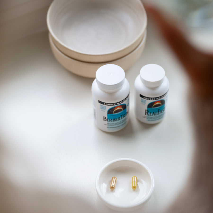 Metabolic Reset Kit on a table with a small bowl containing capsules.
